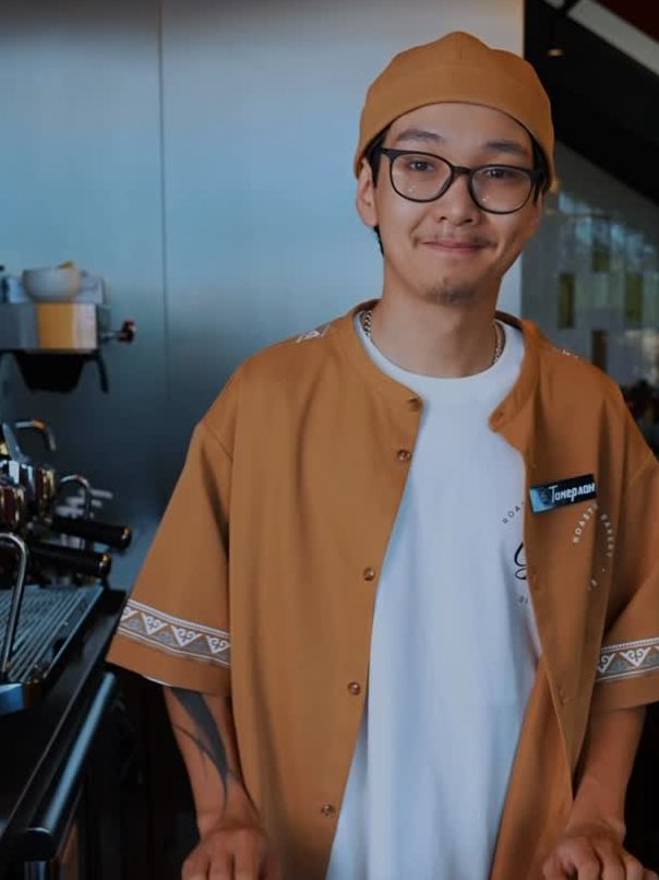 A CBRB barista with a tray at the bar